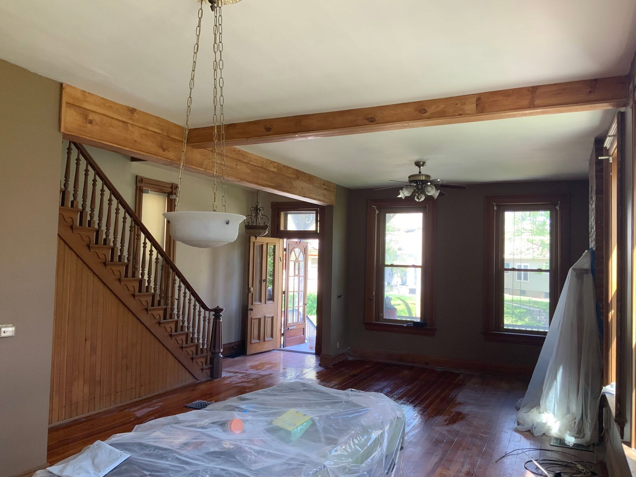 An open living room with exposed structural beams where two walls used to be.